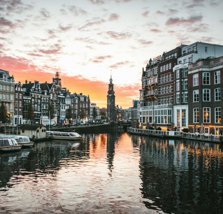 Things to do in Amsterdam. A river with boats on it and buildings in the background