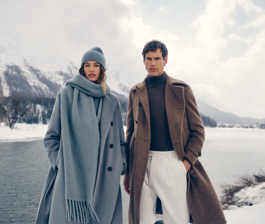 a man and woman in white clothes standing in snow