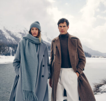 a man and woman in white clothes standing in snow