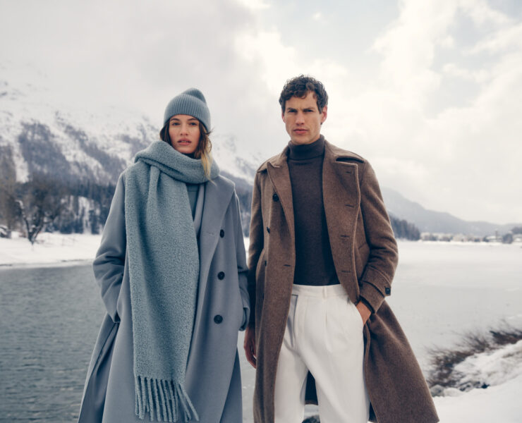 a man and woman in white clothes standing in snow